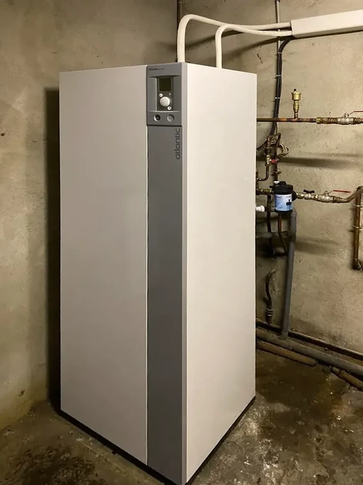 Cave technique avec chaudière à condensation moderne blanche installée au sol